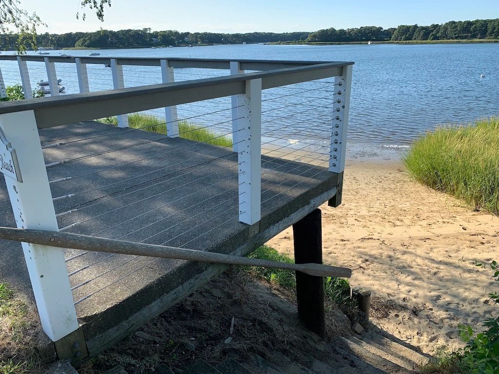 Eine Betonplattform mit Metallgeländern und Blick auf einen See.