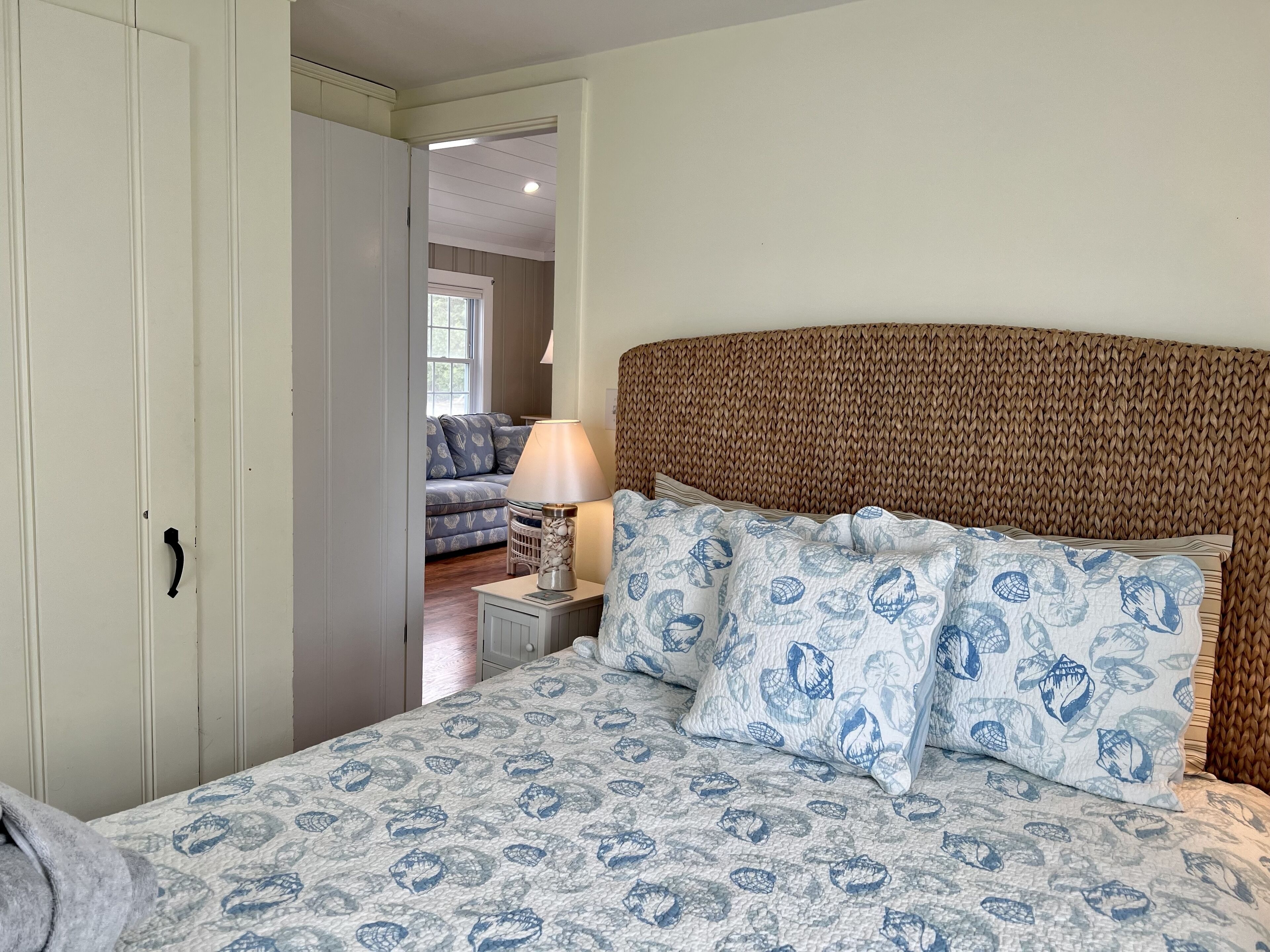 A bedroom with a bed, a nightstand, a lamp, and a wardrobe.