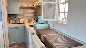 A kitchen with a built-in bench, a window, and a herringbone-patterned backsplash. - Le Petit Bonheur • Quiet • Rooftop • 3 min to Beach (5 de Diciembre)