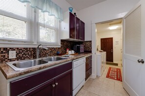 Kitchen features a two-basin sink, dishwasher, and tiled backsplash.