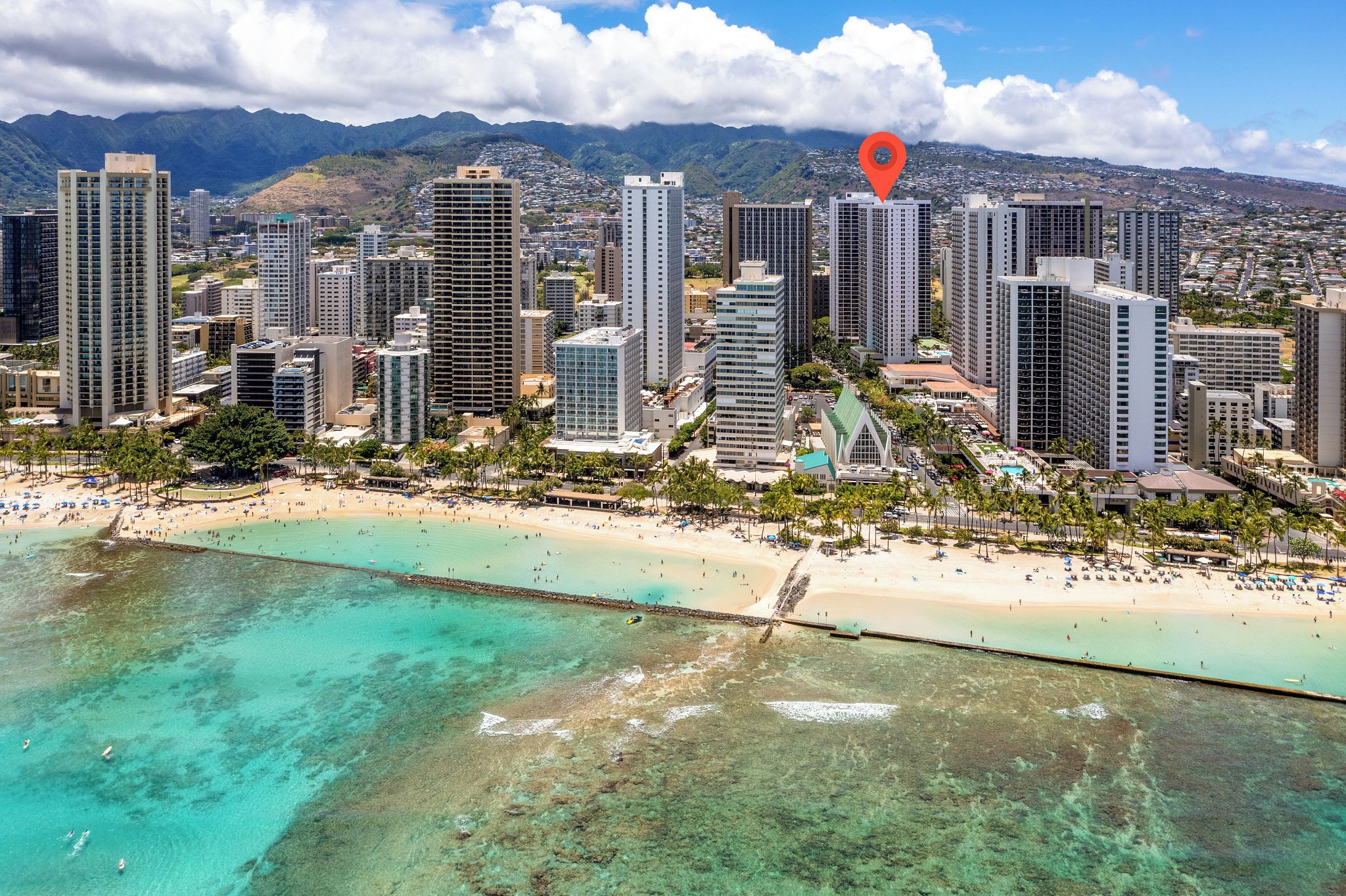 Un paysage urbain côtier avec de hauts immeubles, une plage et une vue dégagée sur l’océan.