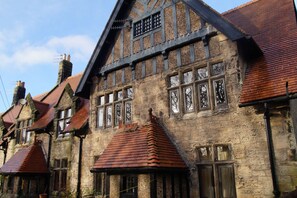 A traditional half-timbered building with multiple chimneys and a steeply pitched roof. - Unique 19th century historic, 2 bedroom apartment. (Rothbury)