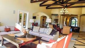A spacious living area with a sofa set, a coffee table, and a chandelier. - Country Club 1104, heated pool, 1000 feet from Golfland Sunsplash Amusement Park (Mesa)