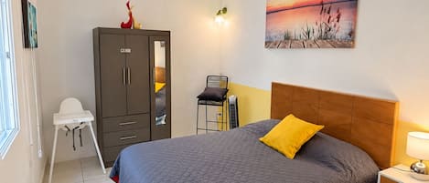 Un dormitorio con cama, armario, escritorio, silla y un cuadro en la pared.