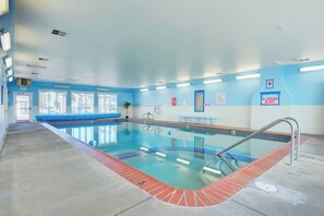 An indoor swimming pool with clear water, a red brick border, and a blue and white wall. - Stunning Beachfront Suite - Sleeps 4 - Second Floor - Pool and Sauna! (Lincoln City)
