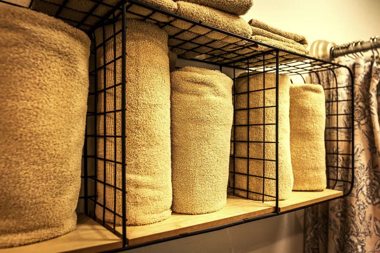 A shelf with neatly stacked towels.