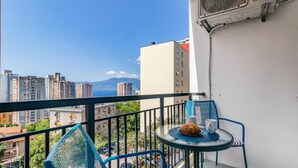 A balcony with a table, chairs, and a fan. - Gorgeous apartment in Rijeka with WiFi (Rijeka)