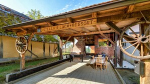 Une structure en bois installée à l’extérieur, sur laquelle est apposée une enseigne indiquant « STELLA & LUCA RESTORT ».