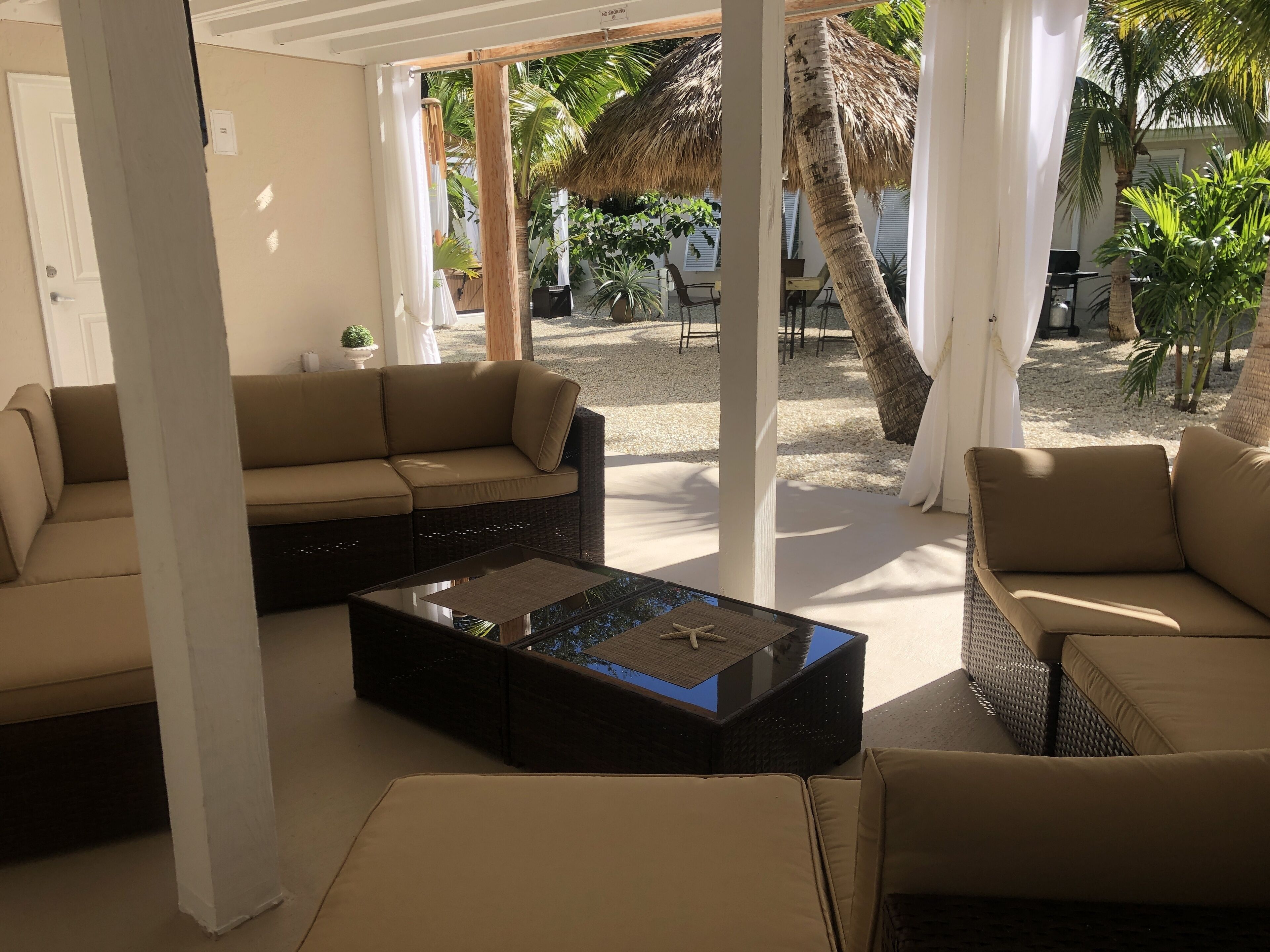 A modern lounge area with a sofa, a coffee table, and a view of the outdoor space.