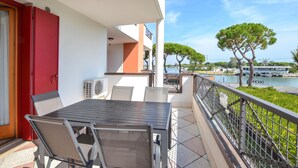 Un balcone con tavolo e sedie, vista su un corso d'acqua e un ponte.