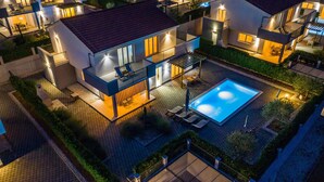 Un moderno complejo residencial con varias casas, una piscina y zonas de estar al aire libre.