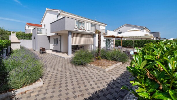 A modern two-story house with a paved courtyard, outdoor seating, and a pool area. - Pet friendly home in Debeljak (Debeljak)