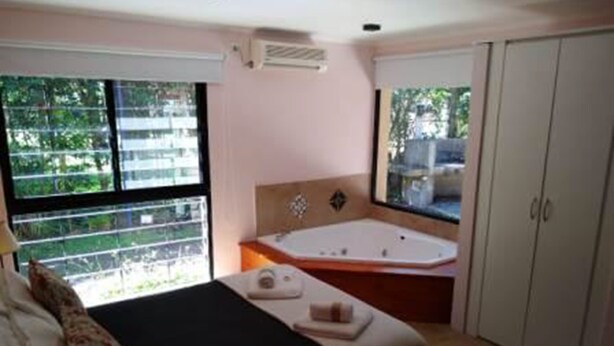 A bedroom with a bed, a window, a bathtub, and a wardrobe. - Ruca Lemu (Chascomus)