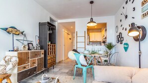 A cozy living room with a sofa, a dining table set with dishes, and a kitchen in the background. - Nice apartment in Mijas Costa with swimming pool (Mijas Costa)