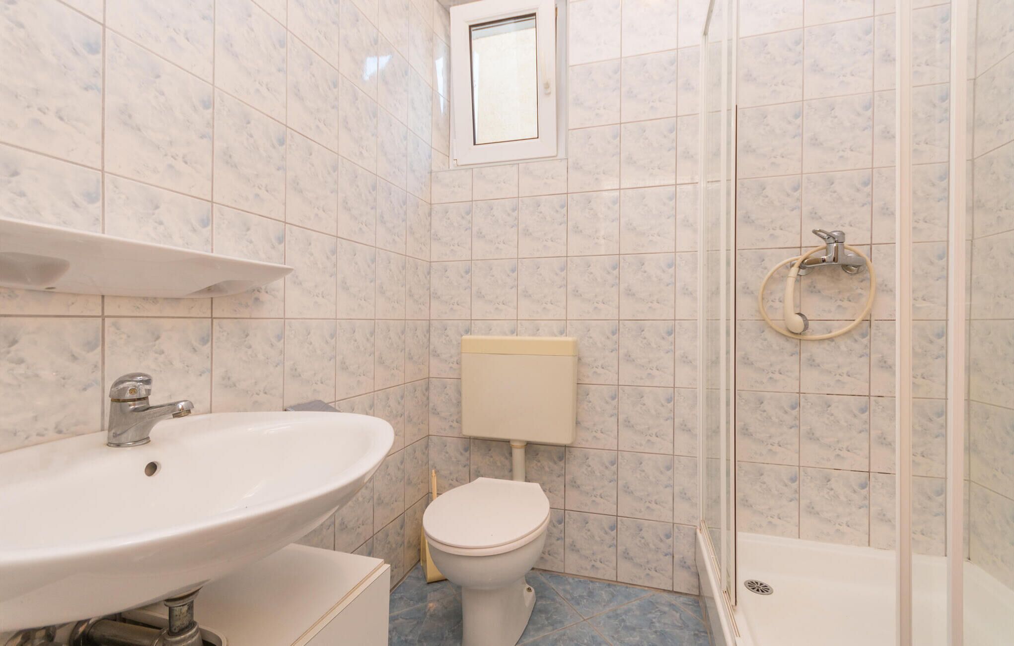Un baño con lavamanos, inodoro y ducha.