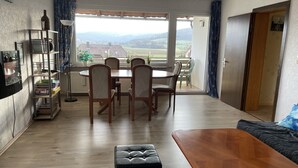 Un coin repas comprenant une table et des chaises, un canapé et un banc en bois.
