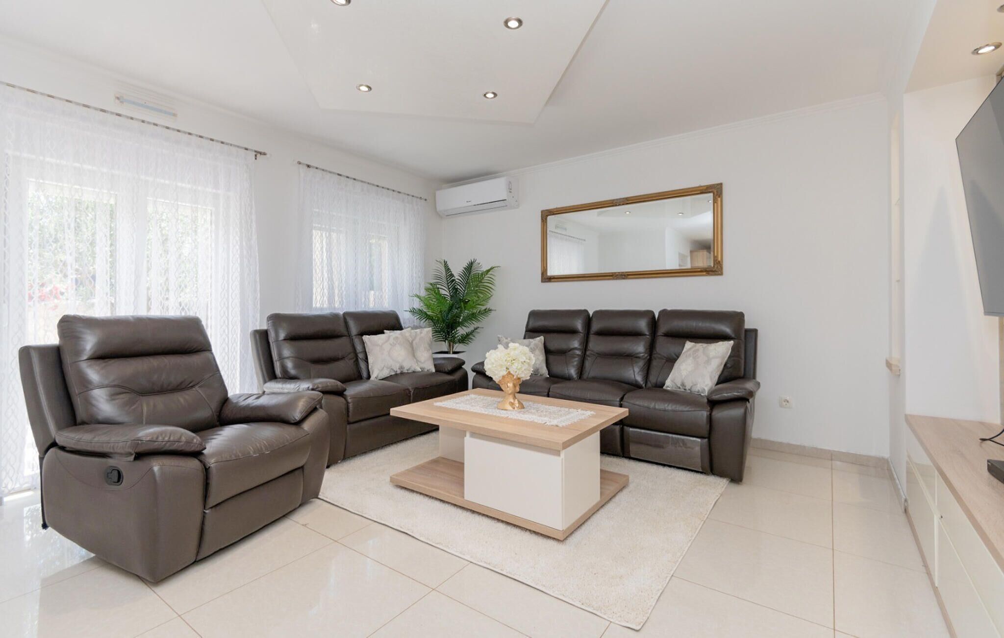 Een moderne woonkamer met een hoekbank, een fauteuil en een salontafel.