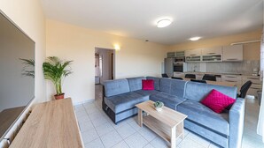 Una sala moderna con un sofá modular, una mesa de centro de madera y una planta en maceta.