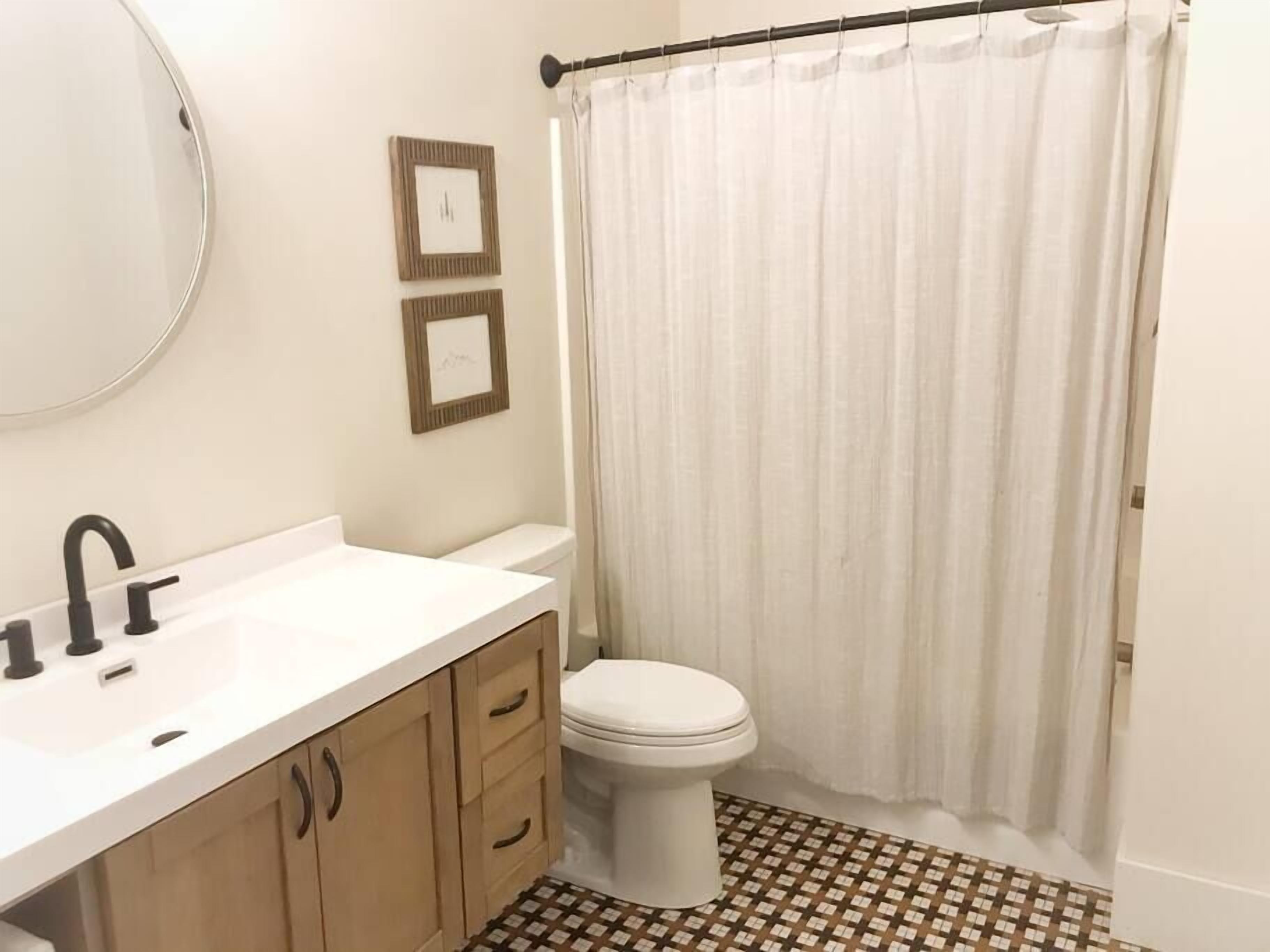 A bathroom with a white sink, a toilet, and a shower curtain.