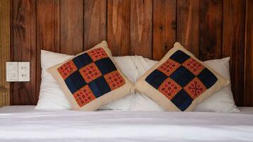 A bed with two pillows featuring a geometric pattern.