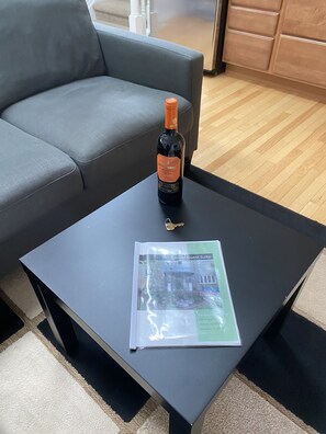 Une bouteille de vin sur une table noire, accompagnée d’une brochure et d’une clé.
