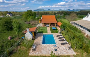 A residential property with a swimming pool, outdoor seating, and a view of mountains. - Amazing home in Lovinac with sauna (Lovinac)