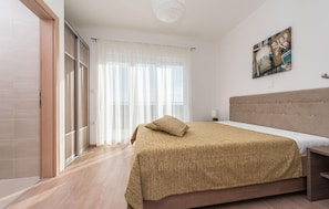 A bedroom with a bed, a headboard, a painting, and a window with curtains. - Beautiful home in Debeljak (Debeljak)