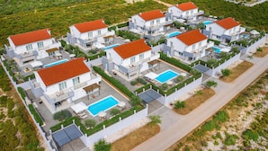 A modern residential complex with multiple two-story houses, each featuring a swimming pool and outdoor seating areas. - Cozy home in Debeljak (Debeljak)