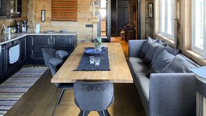 A modern kitchen with dark cabinetry, a wooden dining table, and a gray sofa. - Pet friendly home in Hovden I Setesdal (Hovden I Setesdal)