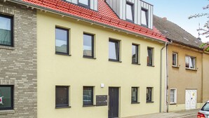 A yellow building with multiple windows and a red roof. - Cozy apartment in Malchow with WiFi (Malchow)