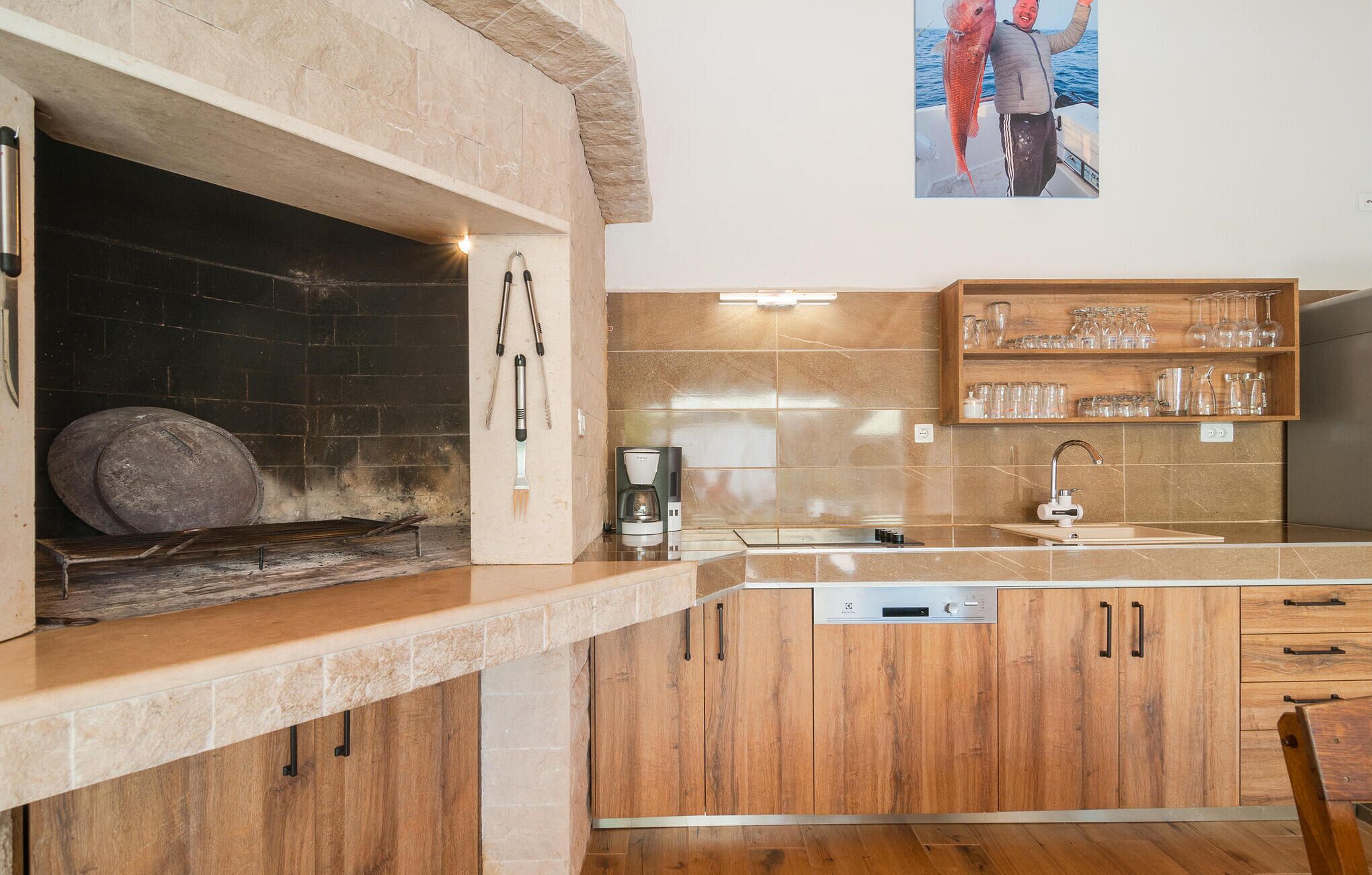 A kitchen with a wood stove, a coffee maker, and a sink.