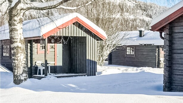 A wooden cabin with a snow-covered roof and a porch. - Cozy home in Sysslebäck with WiFi (Sysslebäck)