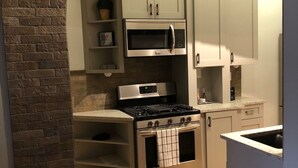 A compact kitchen with a built-in oven, microwave, and gas stove.