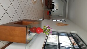 A modern interior with a staircase, a living area with a sofa, and a dining area with a table. - Your best season in Gabriela's land (Ilhéus)