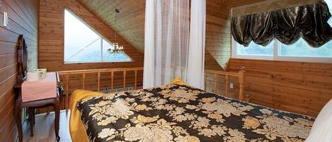 A bedroom with a bed, a window, a chandelier, and a wooden ceiling.