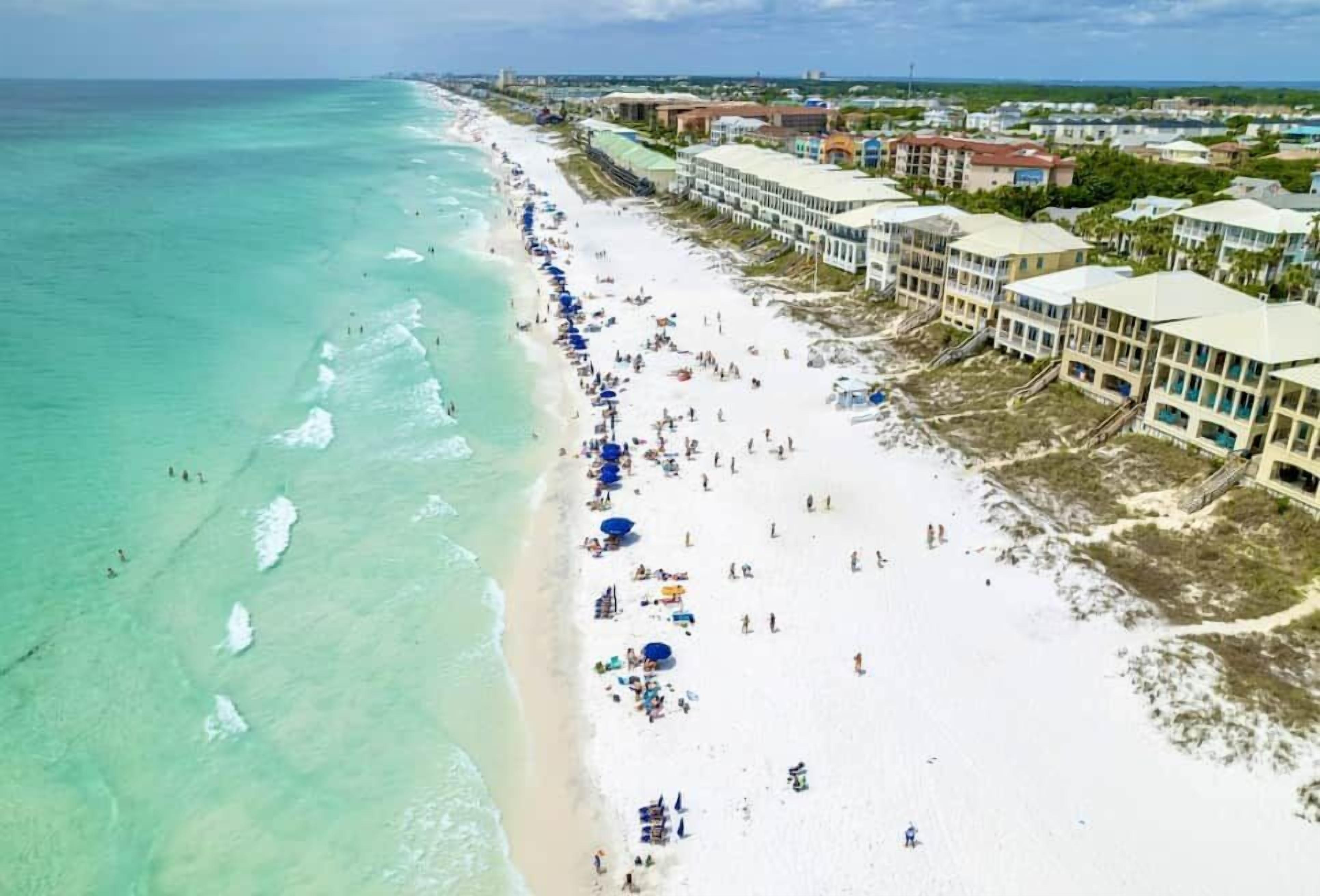 A beach resort with a long sandy beach, ocean view, and beachfront buildings.