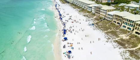 A beach resort with a long sandy beach, ocean view, and beachfront buildings.