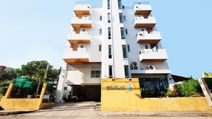 A multi-story building with balconies, a signboard, and a green area with plants. - OYO 605 Lake View Phuket Place (Ratsada)