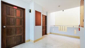 A hallway with two wooden doors, one marked with a number. - OYO 605 Lake View Phuket Place (Ratsada)