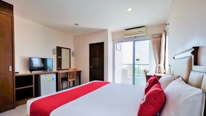 A hotel room with a bed, a TV, a desk, and a balcony with curtains. - OYO 605 Lake View Phuket Place (Ratsada)