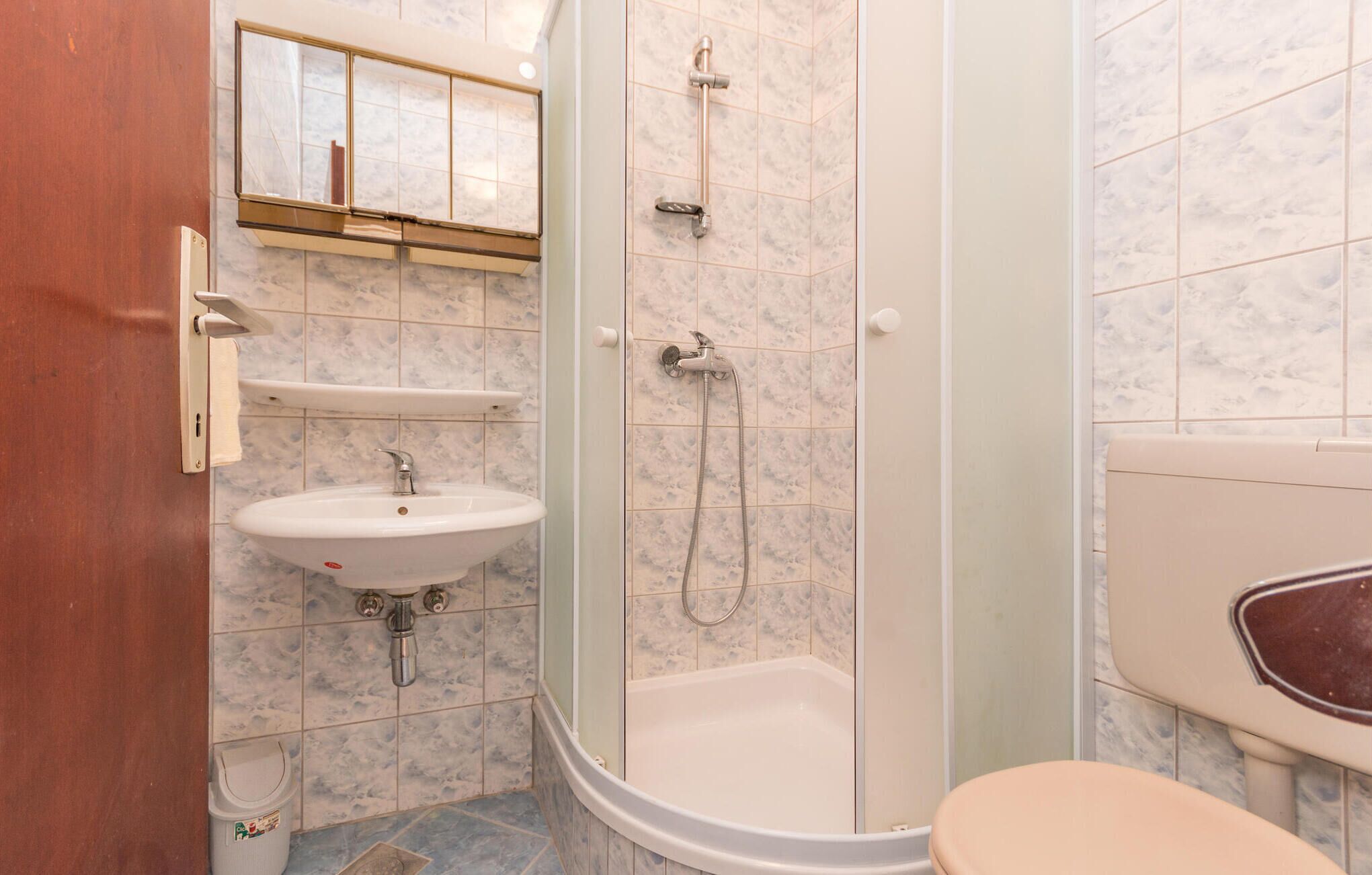 A bathroom with a toilet, sink, and shower.