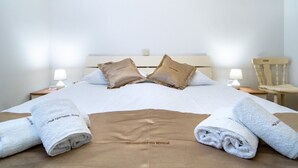 A neatly made bed with two pillows, a wooden headboard, two bedside tables with lamps, and a chair. - Apartment in Lopar with Terrace, Air condition, WIFI, Washing machine (4885-4) (Lopar)