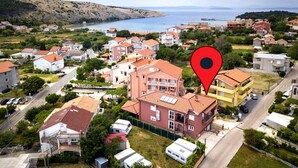 A coastal residential area with houses, a marina, and a large body of water. - Apartment in Lopar with Terrace, Air condition, WIFI, Washing machine (4885-4) (Lopar)