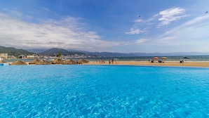 A clear blue pool with a view of a beach and mountains in the background. - Grand Venetian Puerto Vallarta Beachfront Condo  (Puerto Vallarta)