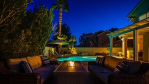 A patio with a pool, outdoor furniture, and a pergola.