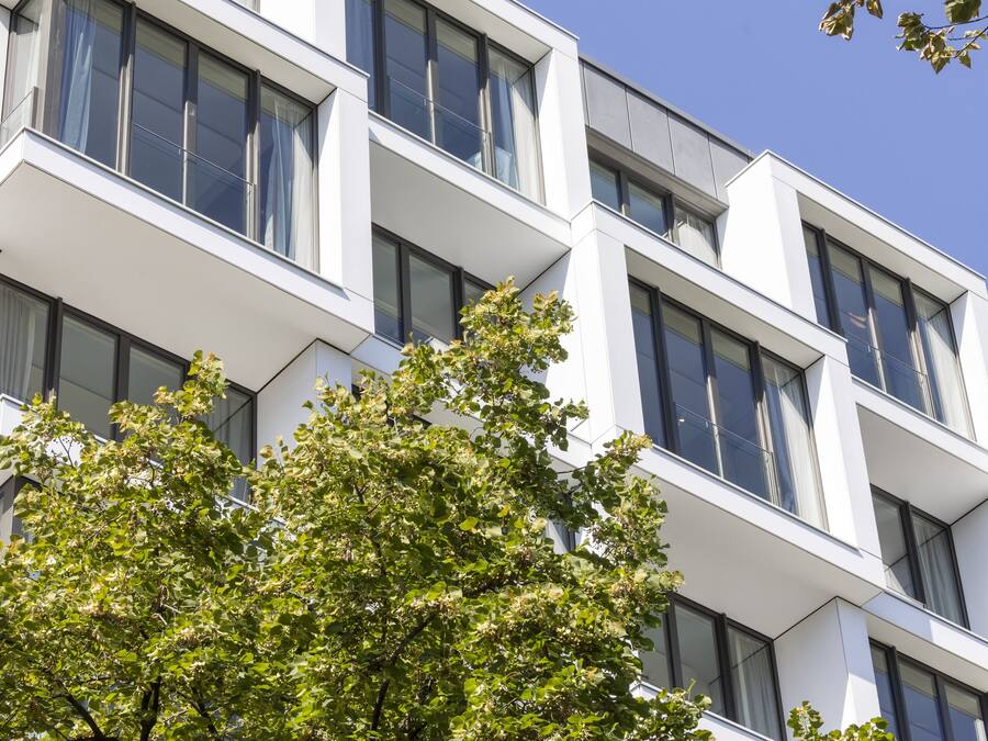 A modern building with multiple windows and a white facade.