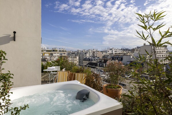 A rooftop terrace with a hot tub, potted plants, and a view of the cityscape. - Quinzerie Hotel (Paris)