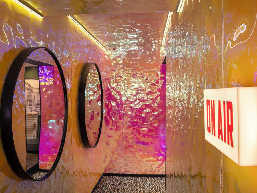 Un pasillo con paredes reflectantes y un letrero que dice 'ON AIR'.