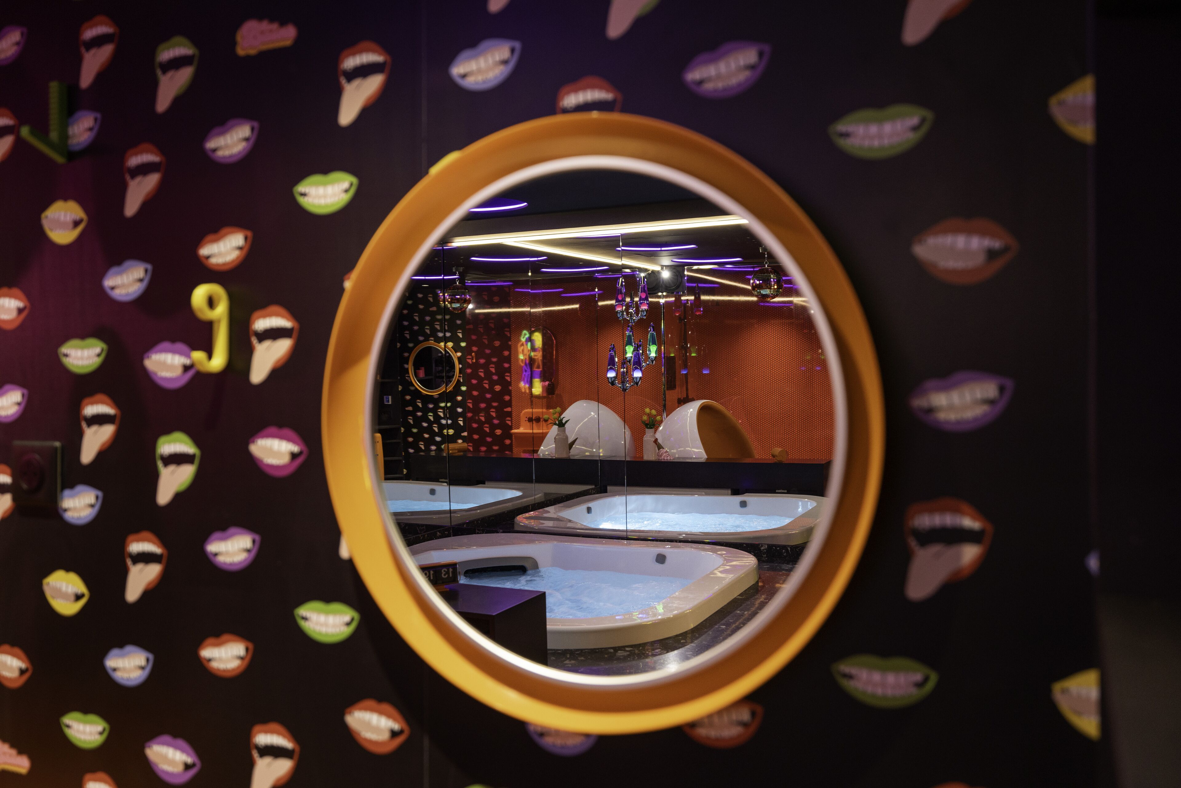 Une salle de bain avec plusieurs lavabos et un miroir qui reflète la pièce.
