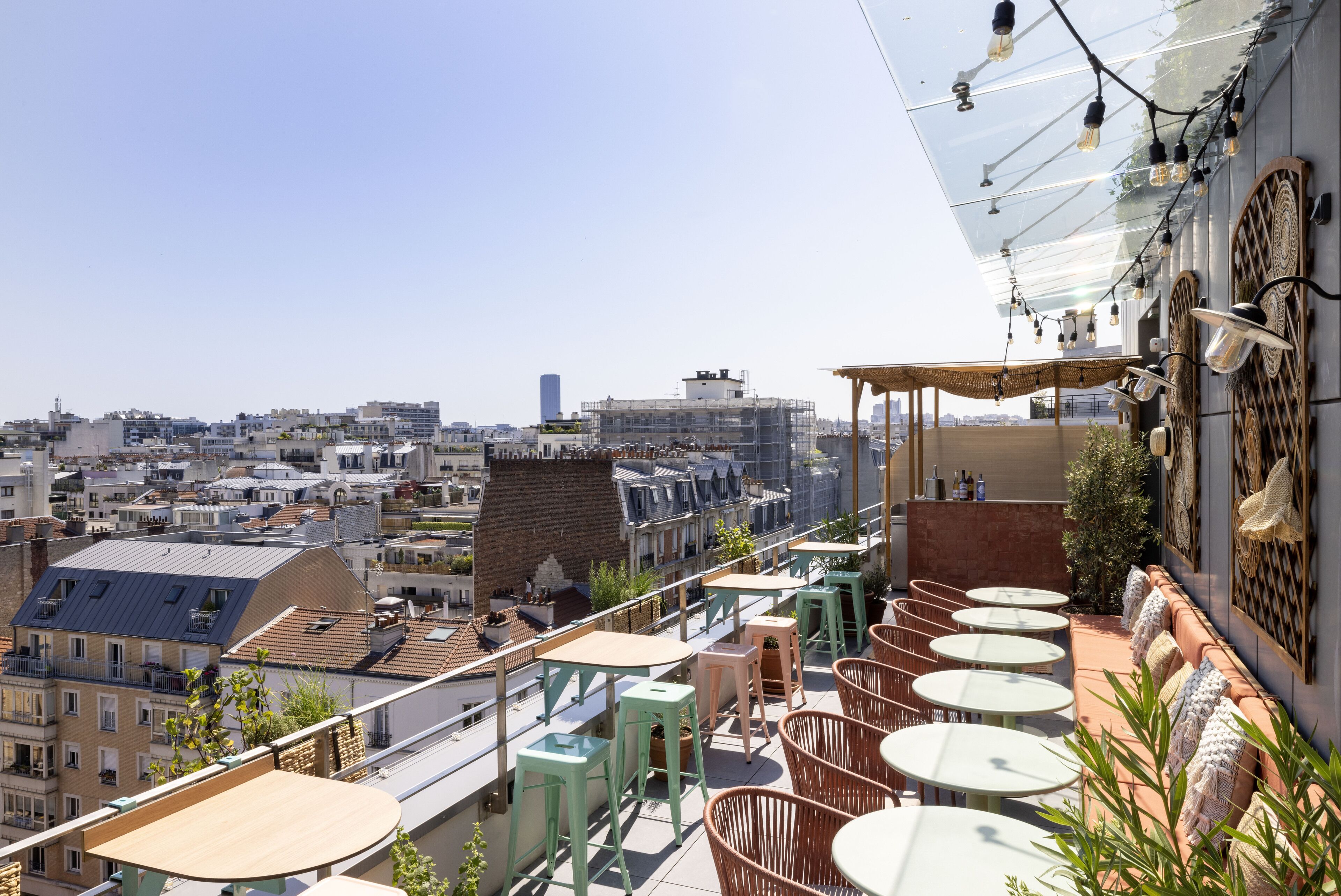 Une terrasse sur le toit avec des sièges en plein air, une vue sur la ville et une verrière.